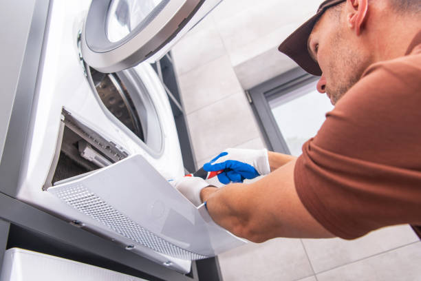 Caucasian Home Appliances Technician in His 40s Repair Broken Washer Inside a Home Bathroom.